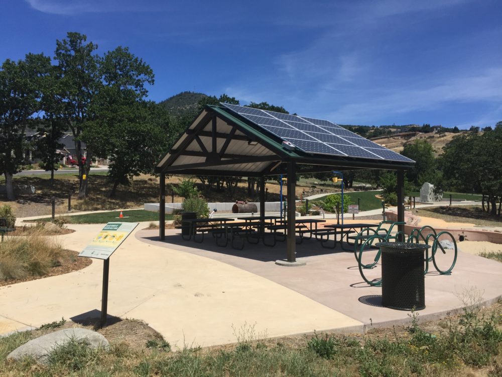 In Medford, Oregon, residents relax under a city-owned 3.3-kilowatt solar shade canopy.